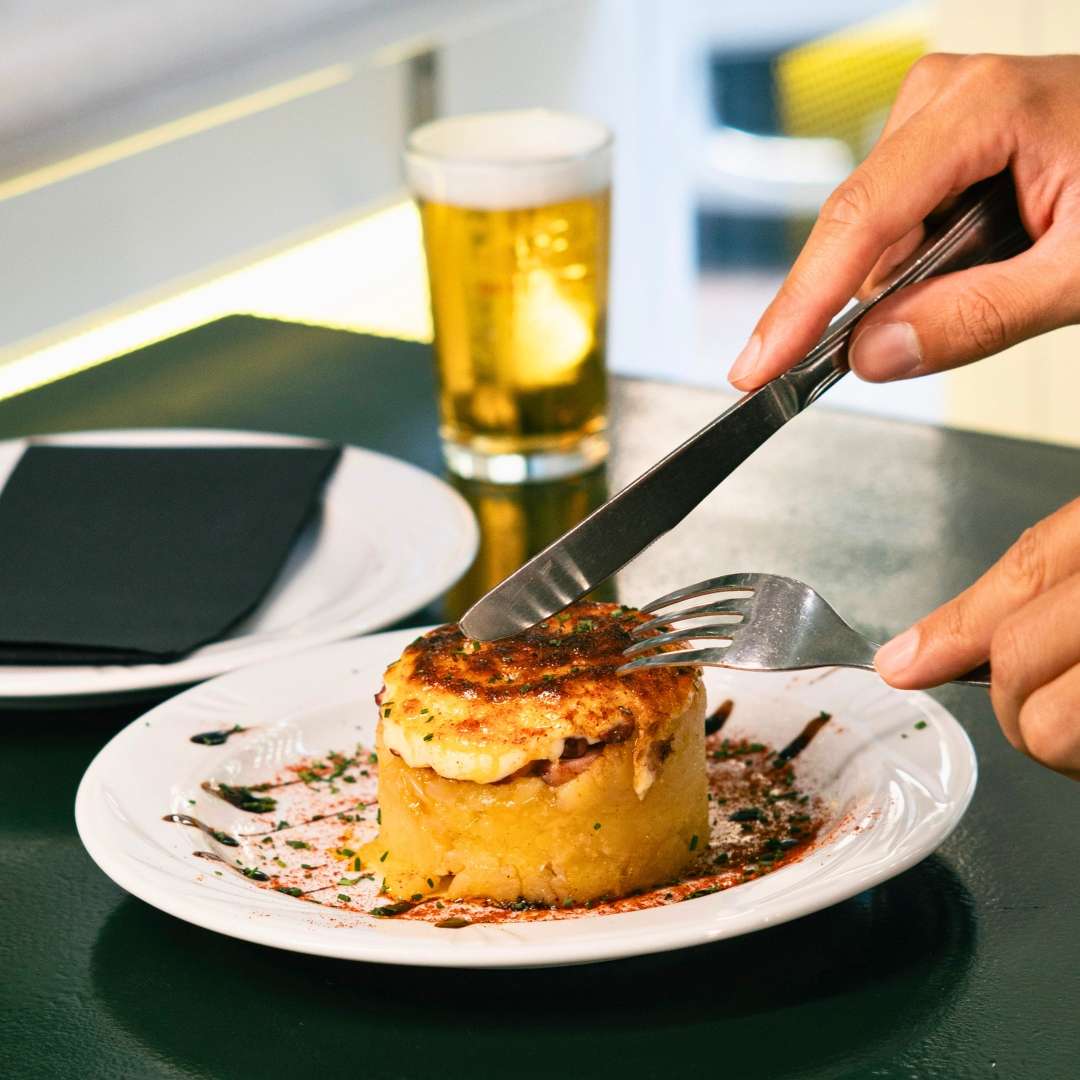 Tapa de pulpo con alioli gratinado sobre cama de patatas en Buendi Alcántara.