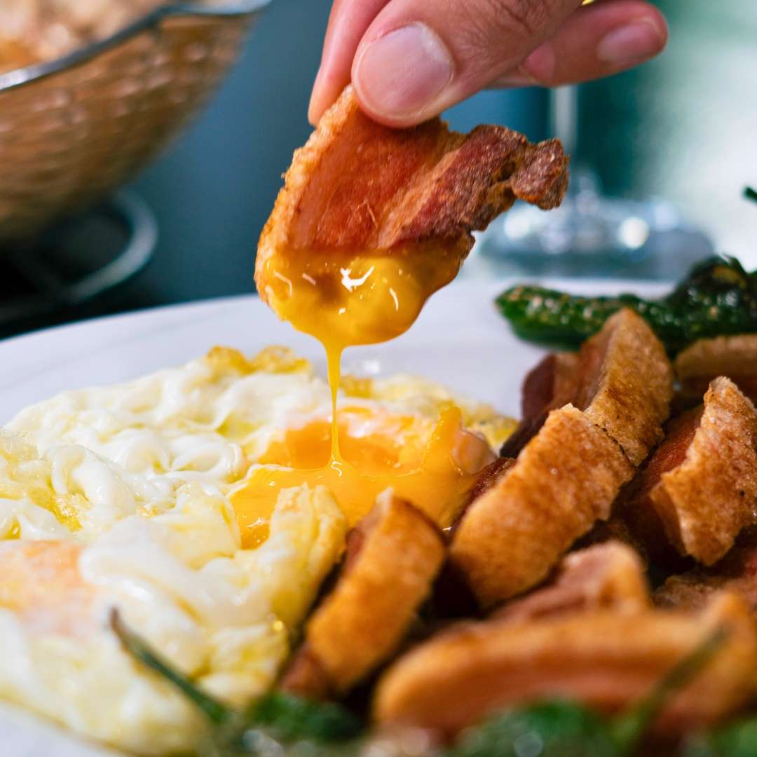 Torreznos de Soria crujientes acompañados de huevos fritos en Buendi Alcántara.